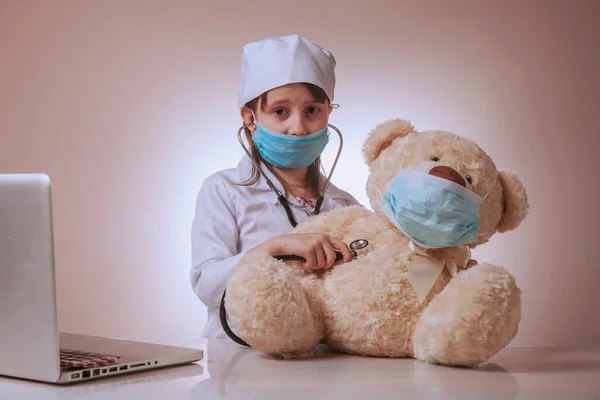 Kleine Süße Traurige Kinderärztin Schutzmaske Checkt Körper Von Spielzeug Teddybär — Stockfoto