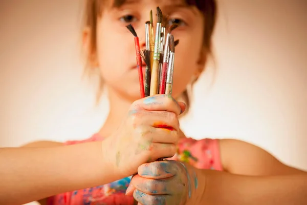 创造力和教育概念 漂亮的小女孩手握着画家的画笔 有选择地专注于刷子 横向图像 — 图库照片