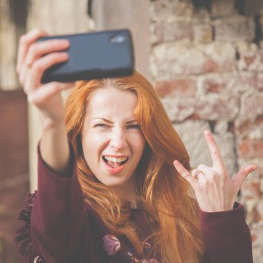 Güzel genç bir kadının cep telefonuyla selphie yaptığı portreyi yakından çek.. 
