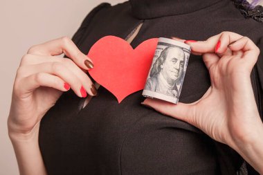 Motivasyon, amaç, kararlılık, aşk ve özgürlük kavramı. Amerikan dolarlarına olan sevginin sembolü olarak kalbi ve parası olan bir iş kadını.. 