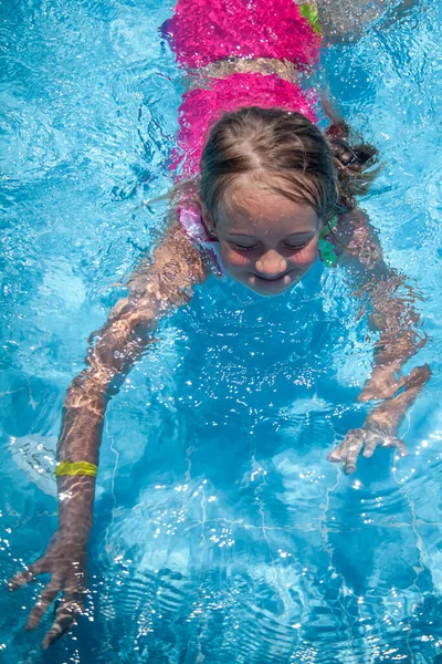 漂亮的小女孩在度假胜地的室外游泳池里 健康的生活方式和快乐童年的概念 — 图库照片