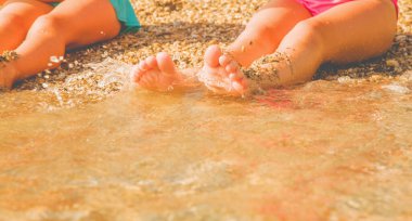 Tatil ve tatil kavramı. Güneşli yaz gününde sahilde güneşlenen iki genç kız. Seçici odaklanma. Yatay resim.