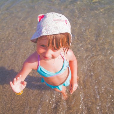 Tatil ve tatil kavramı. Genç kızın güneşli yaz gününde sahilde güneşlenip denizin tadını çıkarmasının en güzel görüntüsü..