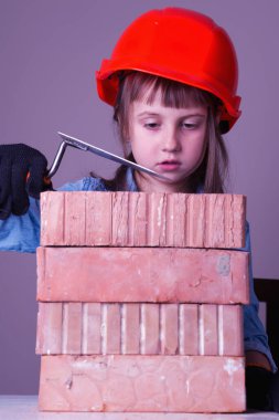 Şirin küçük kız müteahhidin mizahi imajı tuğla ev inşa ediyor.. 