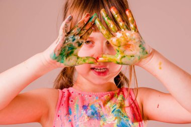 Boyalı ellere bakan genç ve güzel bir kız. Sanat ve resim konsepti. Yatay resim.