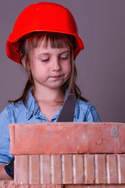 Funny Image Cute Little Child Girl Builder Builds Brick Wall Stock Image