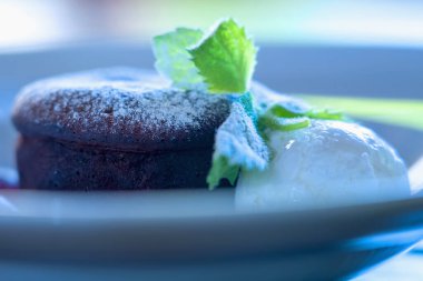 Enfes çikolatalı keki arka planda tabağa koy. Seçici odak.