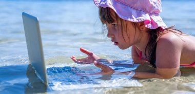 Sen tropikal denizde dizüstü bilgisayarla çalışan güzel bir iş kadınısın. Yatay resim.