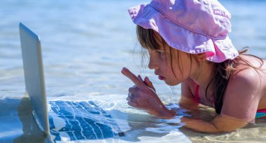 Genç ve güzel bir iş kadınının tropikal denizde dizüstü bilgisayarla çalışmasını kapatın. Yatay resim.
