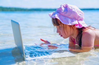 Sen tropikal denizde dizüstü bilgisayarla çalışan güzel bir iş kadınısın.. 