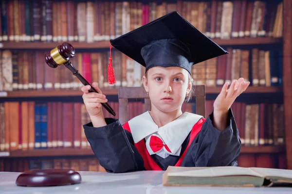 Doubts of the judge in making a decision concept. Portrait of serious child girl judge (lawyer) makes a decision. Humorous photo.