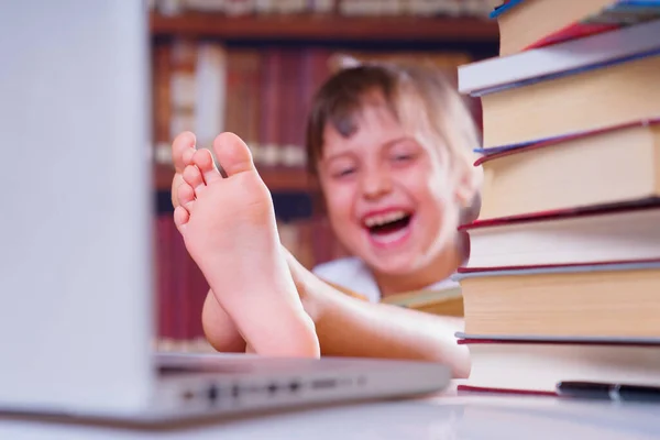 学习会很有趣 年轻笑容可亲的美丽女生与计算机和书籍一起学习的肖像 有选择地专注于脚 — 图库照片