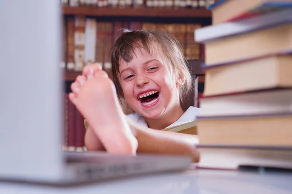 学习会很有趣 年轻笑容满面的美丽女生与计算机和书籍一起学习的画像 — 图库照片