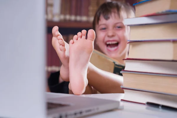 学习会很有趣 年轻的笑着快乐美丽的女生学习与计算机和书籍 有选择地专注于脚 — 图库照片