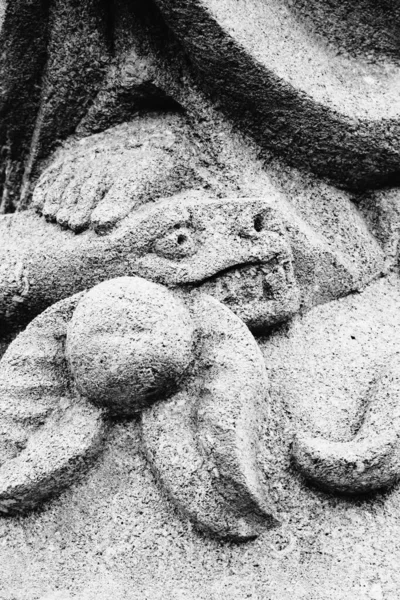 Religious symbol of Christianity: Close up Virgin Mary crushing with her foot the serpent as a symbol of the victory of good over evil. Fragment of ancient statue. Vertical image.