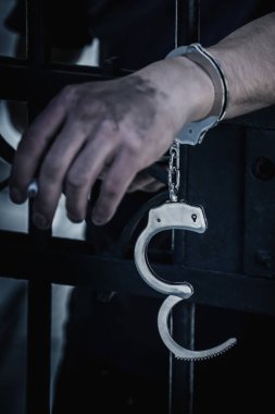 Elleri kelepçeli adam suçtan hapse atıldı, ciddi suçlardan cezalandırıldı. Dikey resim.