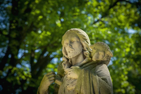 Ancient statue of Good Shepherd Jesus Christ with the lost sheep on his shoulders. (Biblical tradition, religion, Christianity, God, and  faith concept