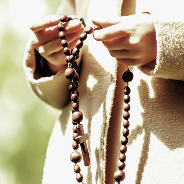 ロザリオを持っている若い女の子の手を閉じてください 祈れ神の概念 — ストック写真