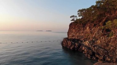 Plaj ve kayalıklarla sabahın erken saatlerinde hava görünümünü. Kum ve deniz dalgaları.
