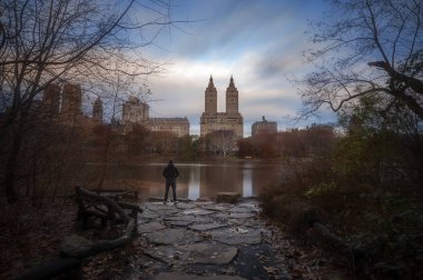 Adam sabah erken gündoğumu ve sonbahar renkleri güzel sonbahar sabahı New York City Central Park içinde ayakta