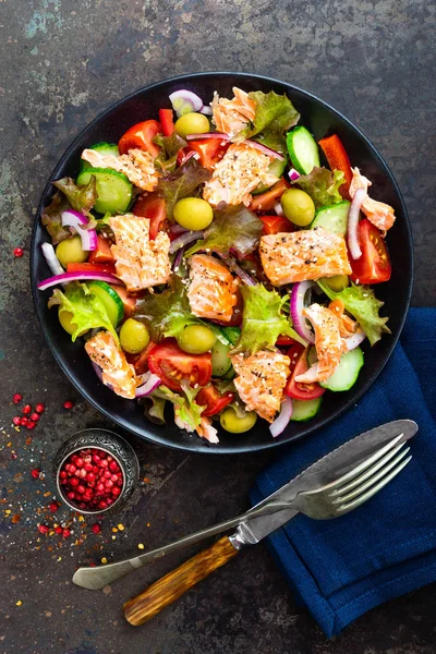 Salad with fish. Fresh vegetable salad with salmon fish fillet. Fish salad with salmon fillet and fresh vegetables on plate