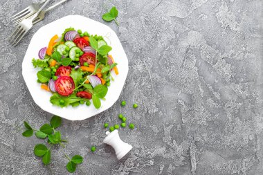 Salata. Domates, soğan, salatalık, biber, marul ve yeşil bezelye ile taze sebze salatası. Vejetaryen tabakta sebze salatası