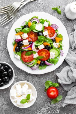 Yunan salatası. Domates, soğan, salatalık, fesleğen, biber, zeytin, marul ve beyaz peynir ile taze sebze salatası. Plaka üzerinde Yunan salatası