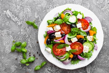 Yunan salatası. Domates, soğan, salatalık, fesleğen, biber, zeytin, marul ve beyaz peynir ile taze sebze salatası. Plaka üzerinde Yunan salatası