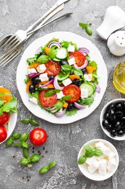 Yunan salatası. Domates, soğan, salatalık, fesleğen, biber, zeytin, marul ve beyaz peynir ile taze sebze salatası. Plaka üzerinde Yunan salatası