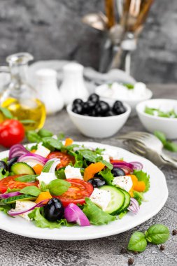 Yunan salatası. Domates, soğan, salatalık, fesleğen, biber, zeytin, marul ve beyaz peynir ile taze sebze salatası. Plaka üzerinde Yunan salatası