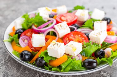 Yunan salatası. Domates, soğan, salatalık, biber, zeytin, marul ve beyaz peynir ile taze sebze salatası. Plaka üzerinde Yunan salatası