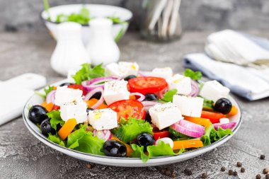 Yunan salatası. Domates, soğan, salatalık, biber, zeytin, marul ve beyaz peynir ile taze sebze salatası. Plaka üzerinde Yunan salatası