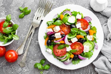 Yunan salatası. Domates, soğan, salatalık, biber, zeytin, marul ve beyaz peynir ile taze sebze salatası. Plaka üzerinde Yunan salatası