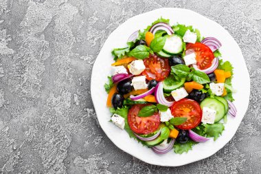 Yunan salatası. Domates, soğan, salatalık, biber, zeytin, marul ve beyaz peynir ile taze sebze salatası. Plaka üzerinde Yunan salatası