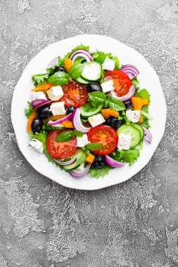Yunan salatası. Domates, soğan, salatalık, biber, zeytin, marul ve beyaz peynir ile taze sebze salatası. Plaka üzerinde Yunan salatası