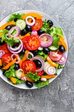 Yunan salatası. Domates, soğan, salatalık, biber, zeytin, marul ve beyaz peynir ile taze sebze salatası. Plaka üzerinde Yunan salatası