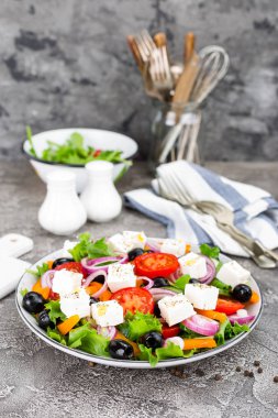 Yunan salatası. Domates, soğan, salatalık, biber, zeytin, marul ve beyaz peynir ile taze sebze salatası. Plaka üzerinde Yunan salatası