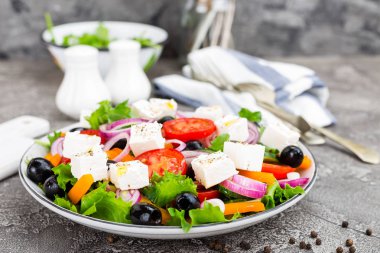 Yunan salatası. Domates, soğan, salatalık, biber, zeytin, marul ve beyaz peynir ile taze sebze salatası. Plaka üzerinde Yunan salatası