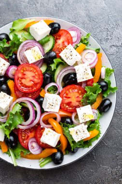 Yunan salatası. Domates, soğan, salatalık, biber, zeytin, marul ve beyaz peynir ile taze sebze salatası. Plaka üzerinde Yunan salatası
