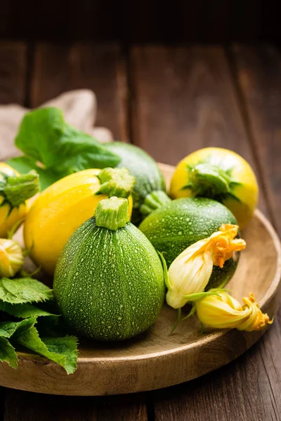 Zucchini Mit Blättern Und Blüten Auf Dunklem Rustikalem Holz — Stockfoto