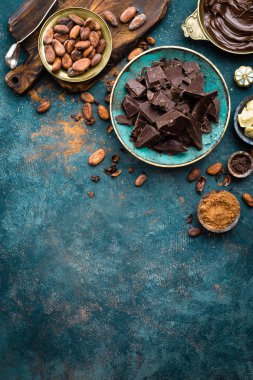 Çikolata. Karanlık bitter çikolata parçaları, kakao yağı, kakao tozu ve kakao çekirdeği. Çikolata arka plan