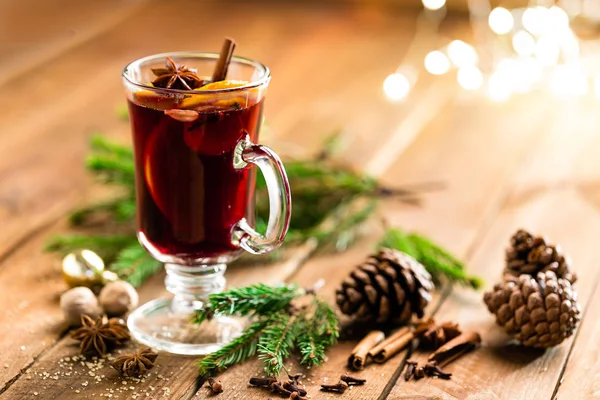 クリスマスはマルド スパイスと木製の素朴なテーブルにオレンジと赤ワインです クリスマスの伝統的なホットド リンク — ストック写真