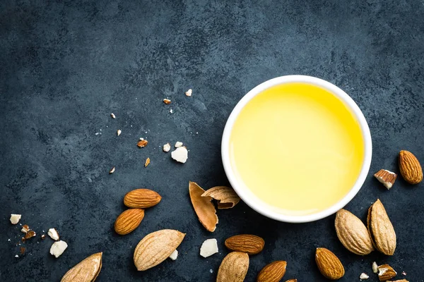 Almond oil in bowl and almond nuts. Almonds