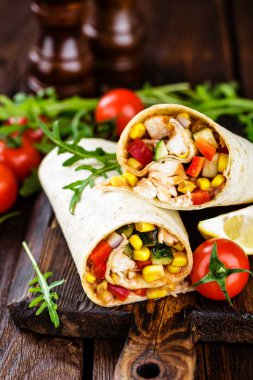 Burrito tamamladı tavuk eti ve sebze ahşap arka plan üzerinde