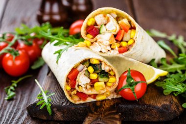 Burrito tamamladı tavuk eti ve sebze ahşap arka plan üzerinde