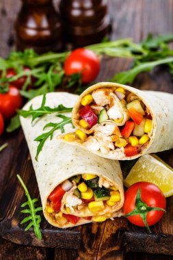 Burrito tamamladı tavuk eti ve sebze ahşap arka plan üzerinde