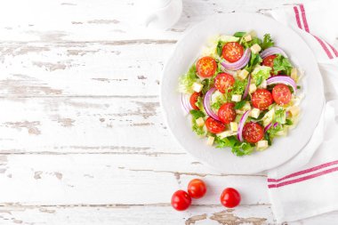 Domates, marul, soğan ve peynir Beyaz ahşap zemin üzerinde taze sebze salatası. Sağlıklı vejetaryen yemek. Üstten görünüm