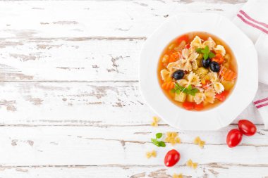 Sebzeli çorba, makarna ve beyaz ahşap rustik arka planda sebze vejetaryen çorbası. Geleneksel İtalyan yemekleri. Üstten görünüm