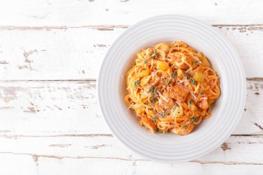 Beyaz ahşap rustik zemin üzerine domates sos, sebze ve tavuk etli spagetti bolognese makarna. Geleneksel İtalyan yemekleri. Üstten görünüm. Düz yatıyordu