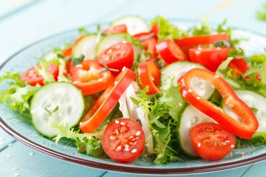 Sağlıklı vejetaryen sebze salatası, taze marul, salatalık, tatlı biber ve domates. Vegan bitkisel kökenli gıda